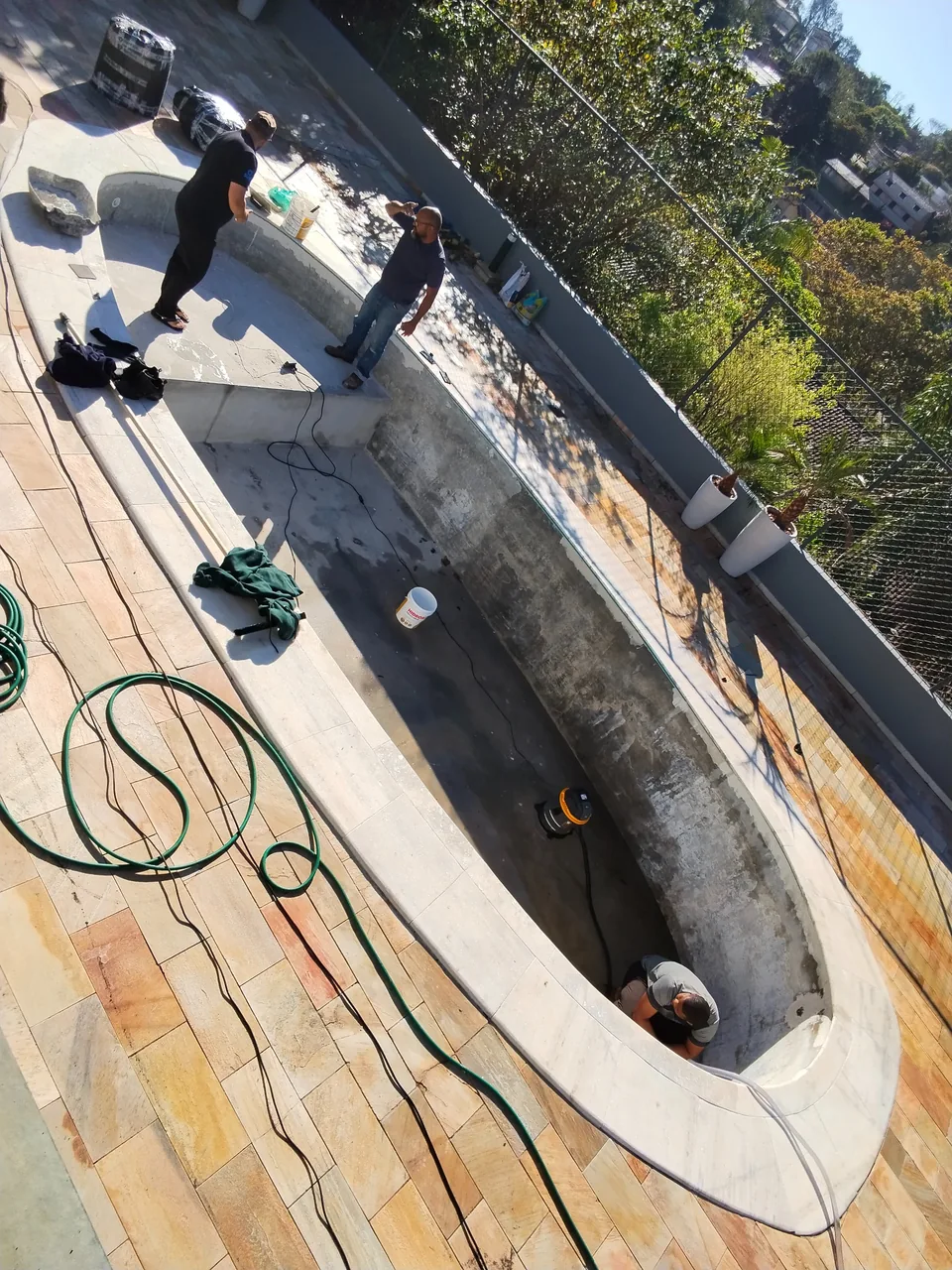 05 retirada preparo Piscina esvaziada durante a reforma, com equipe preparando a estrutura após retirada do revestimento
